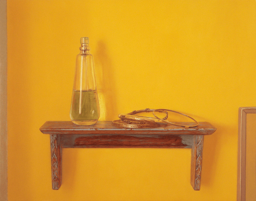 A realist oil painting on panel titled 'Bracelets on Shelf,' measuring 11 inches by 14 inches. A cluster of silver and gold-toned bracelets, including hand hammered and solid polished bands, rests on a blue paint accented, wooden wall shelf. A small clear glass perfume bottle sits to the left of the bracelets. There is a small section of a framed mirror off to the right corner. Strong directional light from the left creates bright, crisp highlights on the metallic and glass surfaces and the detailed highlights on the stacked bands . The background is a creamy, rich yellow, emphasizing the glow of the metal.  Oil painting by John Hansen.
