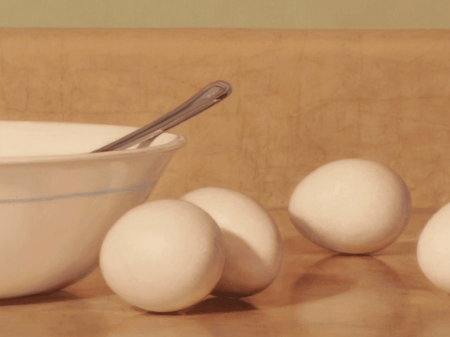 A detailed close-up from the oil painting 'Eggs.' This view focuses on the eggs nestled along side of the bowl, highlighting the smooth, matte texture of the shells and the subtle shadows between them. The detail showcases the fine brushwork used to render the sharp glint of light on the bowl’s edge, the hard metallic handle of the fork, and the rich, realistic reflections on the shinny counter top below. Oil painting by John Hansen.