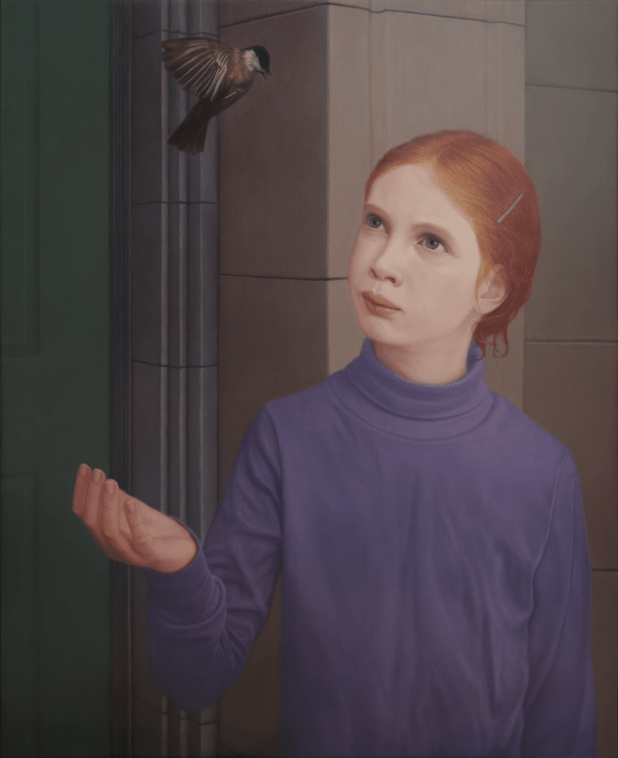 A realist oil painting on panel titled 'Young Girl with a Bird,' measuring 24 1/4 inches by 19 7/8 inches. A young girl with long, reddish-blonde hair held with a hair clip and hidden from view, possibly a pony tail in behind, stands at a doorway outside, holding one hand gently cupped as she looks up at a small bird, a black capped chickadee.. She gazes up at the bird with a quiet, contemplative expression. The background is a softly lit building exterior with a green panelled door. Soft, directional light from the left illuminates her face and the delicate feathers of the bird, creating a serene and focused atmosphere. Oil painting by John Hansen.