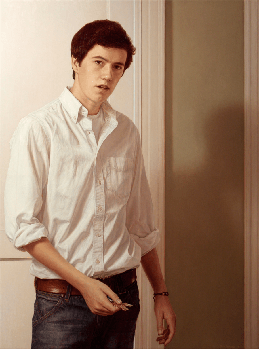 A realist oil painting on panel titled 'Young Man with Keys,' measuring 39 inches by 29 inches. A young man with short brown hair and a slight smile stands in front of a white panelled slightly ajar door. He is dressed casually in a white cotton shirt and white t-shirt, a prominent leather belt holds up his dark blue jeans. In his right hand, he holds a ring of silver keys, he appears to be in the action of heading out as indicated by the dynamic cast shadow of his figure. The lighting is soft and natural, coming from the side to highlight the contours of his face and the metallic surfaces of the keys against the neutral tones of the door and his tactile clothing. Oil painting by John Hansen.